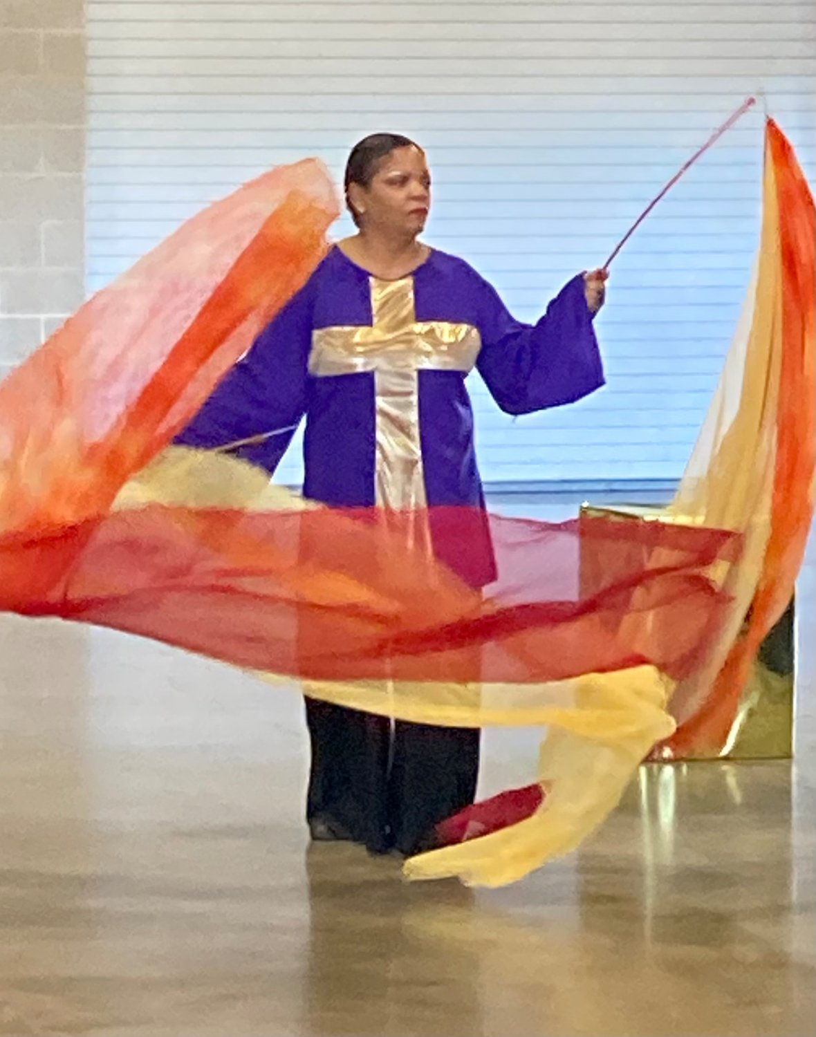 Pam Mayes Jones performs a dance using colorful flags as part of the women’s conference at J.B. Wells Community Center.